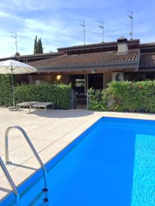 una piscina azul frente a una casa en Casa Vacanze "Il Porticciolo", en Manerba del Garda