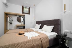 a bedroom with a bed with a hat and towels on it at AKTI Homes Matala in Matala +64 photos