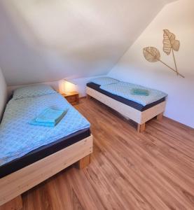 two twin beds in a room with wooden floors at Ferienwohnung Sunny 2 in Mittenwalde