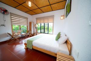 a bedroom with a large bed and a large window at Homestay Thùy Dương 1 in Cai Be