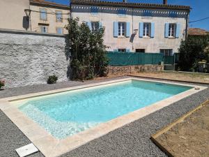 a large swimming pool in front of a building at La maison Vigneronne de Ferdinand à 8mn de Carcassonne in Rouffiac-dʼAude