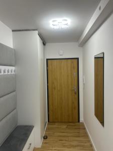 a hallway with a wooden door in a room at Apartament Camila in Leszno