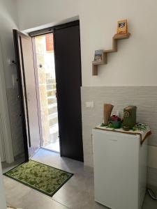 a kitchen with a refrigerator and a door and stairs at Xenia Rooms in Salemi