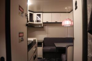 a small kitchen with a couch and a table in a room at Full Service Caravan 1 in Albertslund