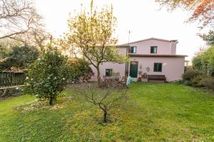 a white house with a garden and a yard with trees at Casa das Regueiras in Santiago de Compostela