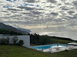 a swimming pool with a view of the water at Grande Mar Villa in Ponta Garça