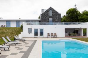 a house with a swimming pool in front of it at Grande Mar Villa in Ponta Garça