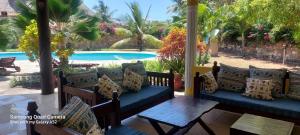 porche con sofá, mesa y piscina en Private 3 Bedroom Villa - Diani, en Ukunda