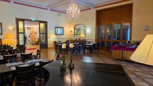 a restaurant with tables and chairs and a chandelier at Eifeler Hof - Ihr Restaurant für Genussmomente in Kyllburg in Kyllburg