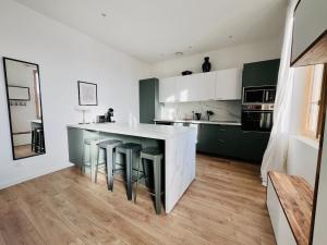 una cucina con armadi verdi e un bancone con sgabelli di Charming townhouse Air conditioning and Parking a Montauban Altre 23 foto