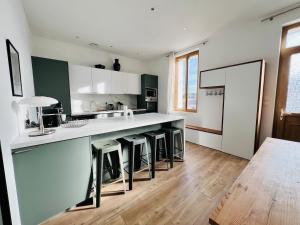 una cucina con bancone e alcuni sgabelli di Charming townhouse Air conditioning and Parking a Montauban