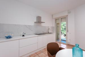 Una cocina con gabinetes blancos y una mesa. en BG apartment, en Senigallia