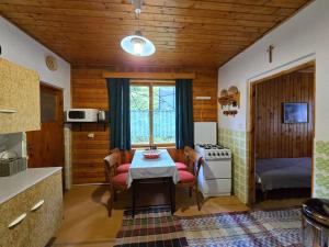 a kitchen with a table and chairs in a room at Chata pri jazierku - Cottage by the Little Lake in Nižná Boca