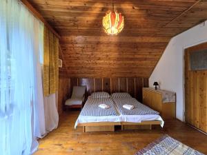 a bedroom with a bed and a chandelier at Chata pri jazierku - Cottage by the Little Lake in Nižná Boca