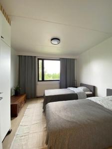 a hotel room with two beds and a window at Cozy apartment from Raahe! in Raahe