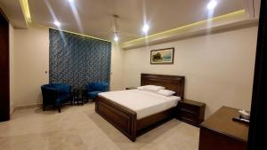 a bedroom with a bed and a table and chairs at Peace House II in Islamabad