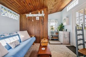 un soggiorno con divano blu e soffitto in legno di Cozy Tiny Home Retreat on Shenandoah Valley Farm cabin a Mount Jackson