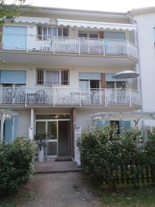 リド・ディ・イエゾロにあるCasa Marialuigia - Appartamenti per famiglieの白いバルコニーと中庭付きのアパートメントビル