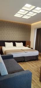 a bedroom with two beds and a couch at Hotel Panorama Gareji in Sagarejo
