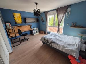 a bedroom with blue walls and a bed and a desk at Maison à la campagne 14 couchages - Jardin - Bain nordique 