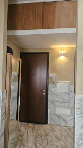 a brown door in a room with marble walls at AURY HOME -Corso XX Settembre in Cremona +8 photos