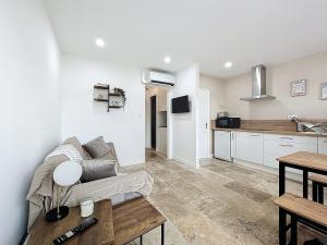 a living room with a couch and a kitchen at Lakanaille - Appartement proche du centre - Wifi et Climatisation in Narbonne