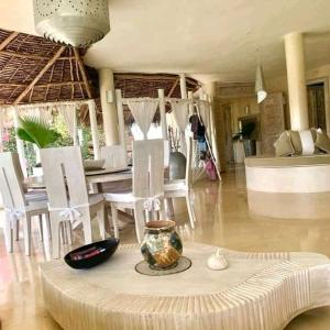 una sala de estar con una mesa y sillas en Beach House Fortamu, en Watamu