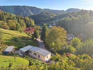 a small house on a hill with mountains in the background at Lexi Zen House in Kamnik