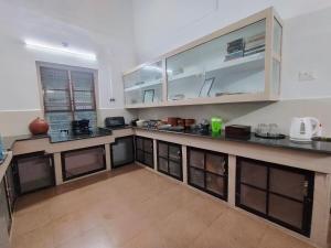 cocina grande con paredes blancas y encimeras de madera en Maanasam Farmstay - Boutique 3BR Countryside Villa, Manikkadavu, en Irrity 56 fotos más