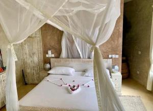 Un dormitorio con una cama blanca con dosel. en Beach House Fortamu, en Watamu 48 fotos más