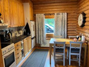 a kitchen with a table and chairs in a cabin at Kivisalmi ja AuroraHut in Viitasaari