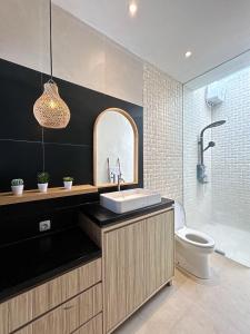een badkamer met een wastafel en een toilet bij Clover Cove Villa in Tabanan