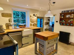 a kitchen with a sink and a counter top at Arwel Cottage 3 bedroom in Llanbedrog