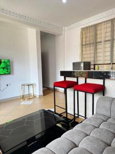 a living room with a couch and red stools at Diani 1 bedroom Apartment in Ukunda