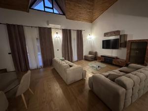 een woonkamer met 2 banken en een televisie bij Villa oasis, Résidence Nianing in Nianing