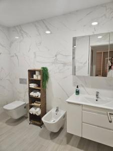un bagno con lavandino, WC e specchio di Me&You - Apartamento em Sesimbra - 5 minutos a pé da praia a Sesimbra