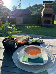 a table with a bowl of soup on a plate at Cabana Plapumioara in Crucea
