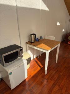 a small table with a microwave on top of it at Saules namu kambariukas in Palanga