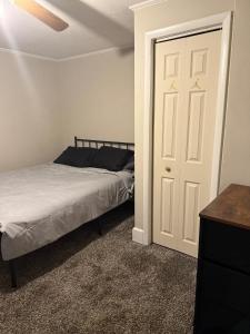 a bedroom with a bed and a white door at Casa Minimal Cottage Pet Friendly with Fenced Yard in Raeford