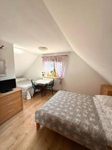 a bedroom with two beds and a table and a window at Waszka in Białowieża