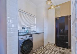 ミッドラントにあるCarlswald Luxeのバスルーム(洗濯機、乾燥機、シンク付)
