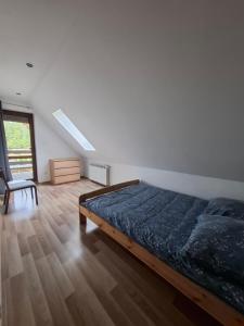 a bedroom with a bed and a chair in it at Dom u Julii Bieszczady in Ustrzyki Dolne