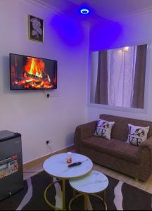 a living room with a couch and a fire in the wall at Freetime zone in Dar es Salaam