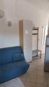 a blue couch in a living room with a refrigerator at Estensi 14 in Lido degli Estensi