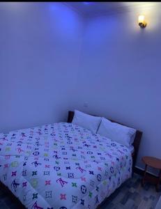 a bedroom with a bed with a colorful comforter at Freetime zone in Dar es Salaam +2 photos