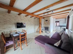 ein Wohnzimmer mit einem lila Sofa und einem Tisch in der Unterkunft Dom u Julii Bieszczady in Ustrzyki Dolne