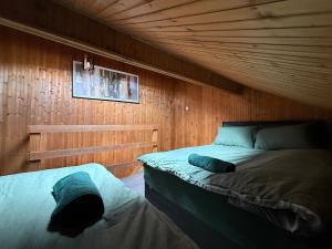 a bedroom with two beds and a wooden wall at Bradford Serviced Accommodation - Apartments - 2 Bed House-Close To Centre - Hospital - Contractors - Business Travellers - Families in Bradford