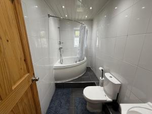 a bathroom with a tub and a toilet and a sink at Bradford Serviced Accommodation - Apartments - 2 Bed House-Close To Centre - Hospital - Contractors - Business Travellers - Families in Bradford +37 photos