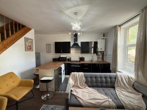 a living room with a couch and a kitchen at Bradford Serviced Accommodation - Apartments - 2 Bed House-Close To Centre - Hospital - Contractors - Business Travellers - Families in Bradford