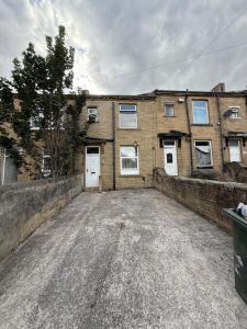 an empty parking lot in front of a brick building at Bradford Serviced Accommodation - Apartments - 2 Bed House-Close To Centre - Hospital - Contractors - Business Travellers - Families in Bradford